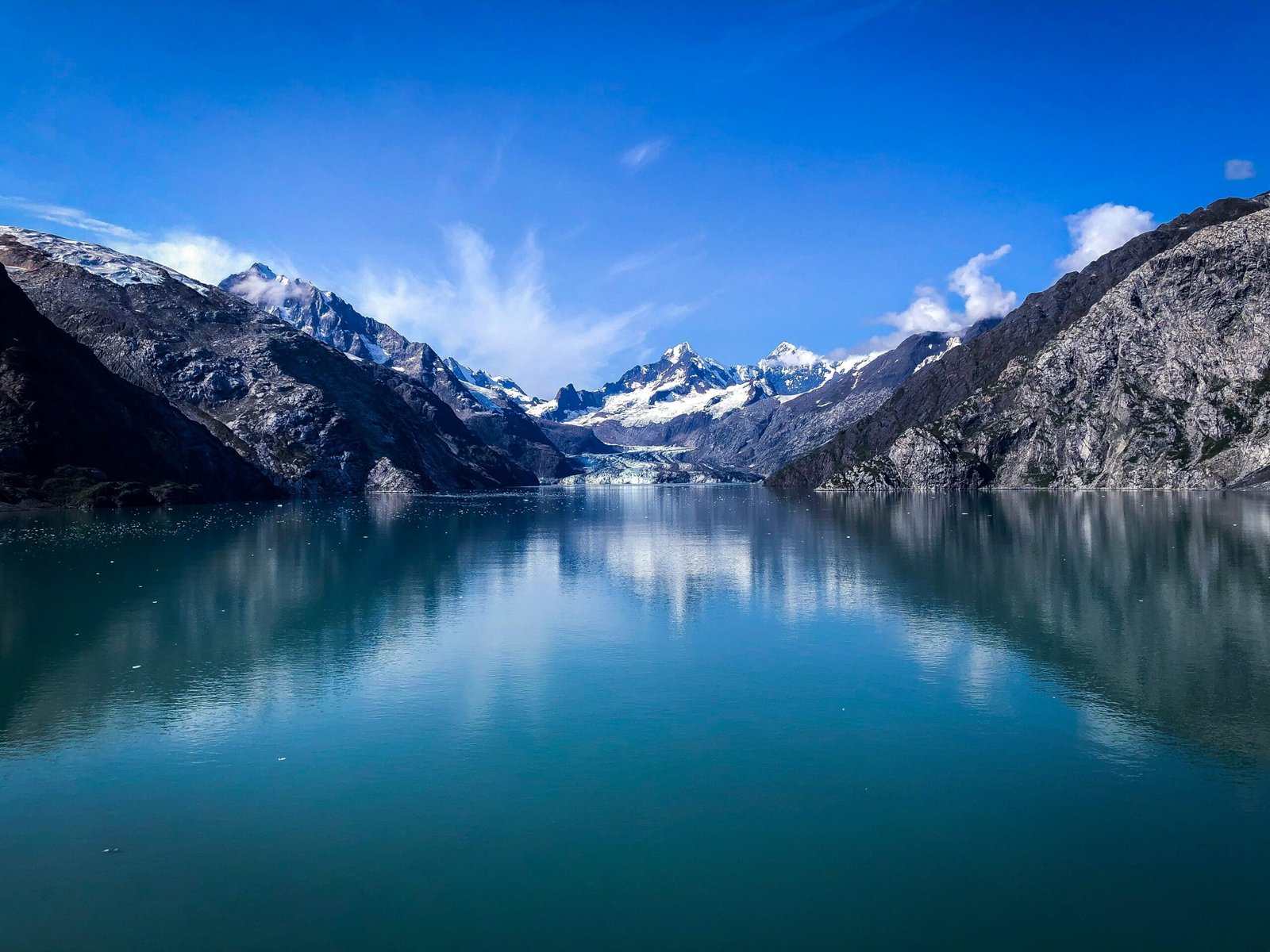 lake near snow covered mountain under blue sky during daytime